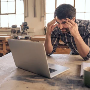 Stressed business owner faces computer issues, considering managed it services for faster, reliable problem resolution