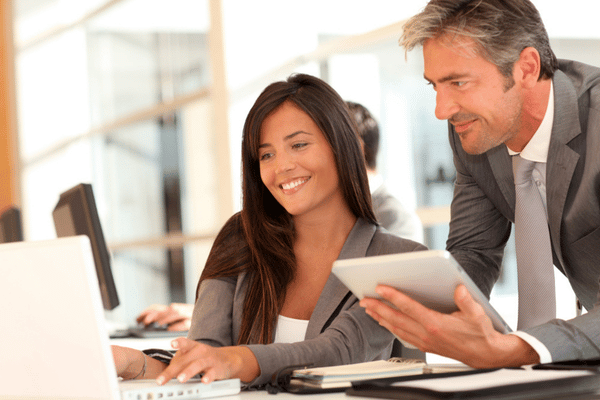 Two professionals collaborate on a laptop, planning upgrades with managed it services to improve productivity