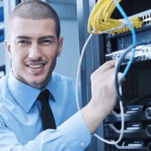 Smiling technician managing network cables in a server rack