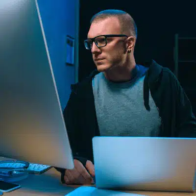 Security analyst studies data across screens, planning upgrades to it support services infrastructure for clients