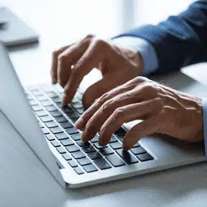 Hands typing on a laptop keyboard, symbolizing proactive IT support through continuous system monitoring