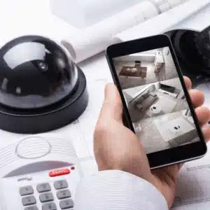 Person checking live home security feed on smartphone after performing cctv maintenance for optimal camera performance