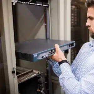 IT technician installing rack-mounted server equipment to prevent or troubleshoot server failure incidents