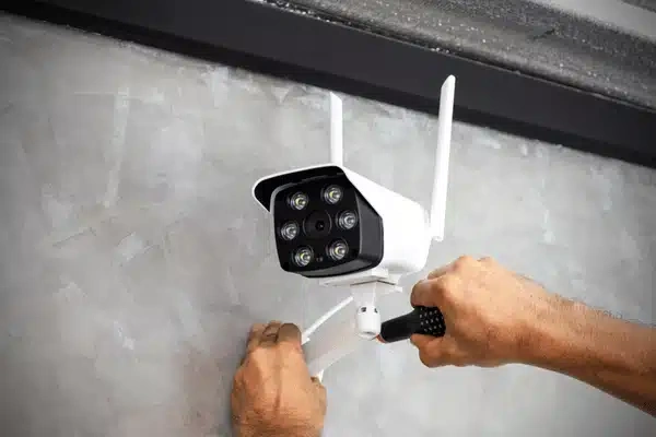 Technician adjusting security camera during cctv maintenance, ensuring proper positioning and secure installation for reliable surveillance