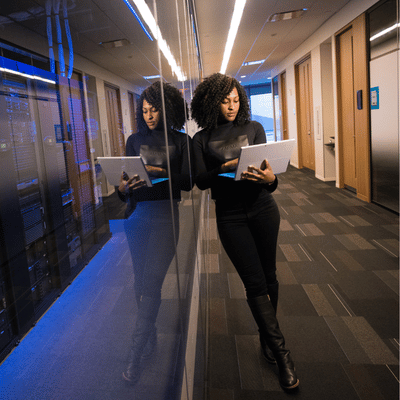 An IT manager checks infrastructure notes in a server room during a Lenovo vs Dell workstation planning review