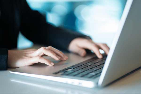 A professional types on a laptop at a desk while using IT services for small business support